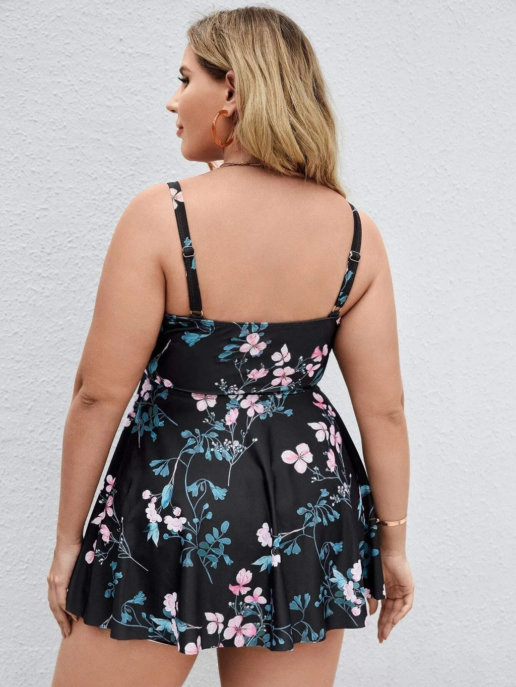 Women's floral print one-piece swimsuit on a hanger, showing split colour pattern.
