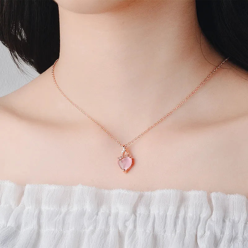 Rose gold necklace with heart-shaped pink crystal pendant and cross chain design