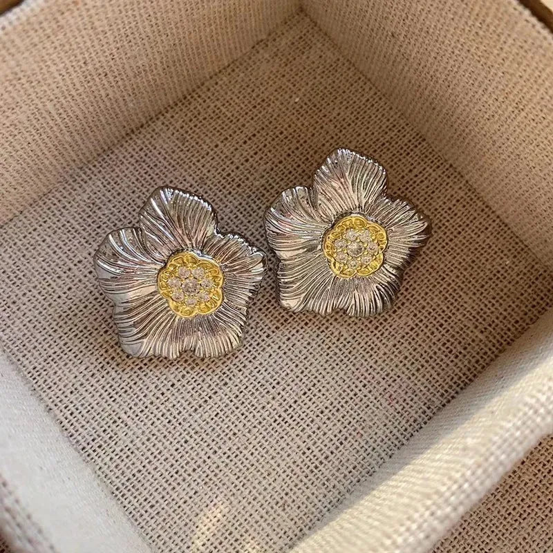 Retro textured two-tone copper stud earrings with gardenia petal motif on white background