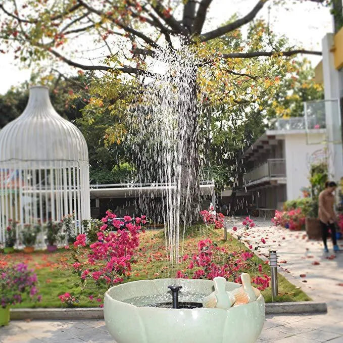 Solar floating fountain with round black panel and four spray nozzles on water surface