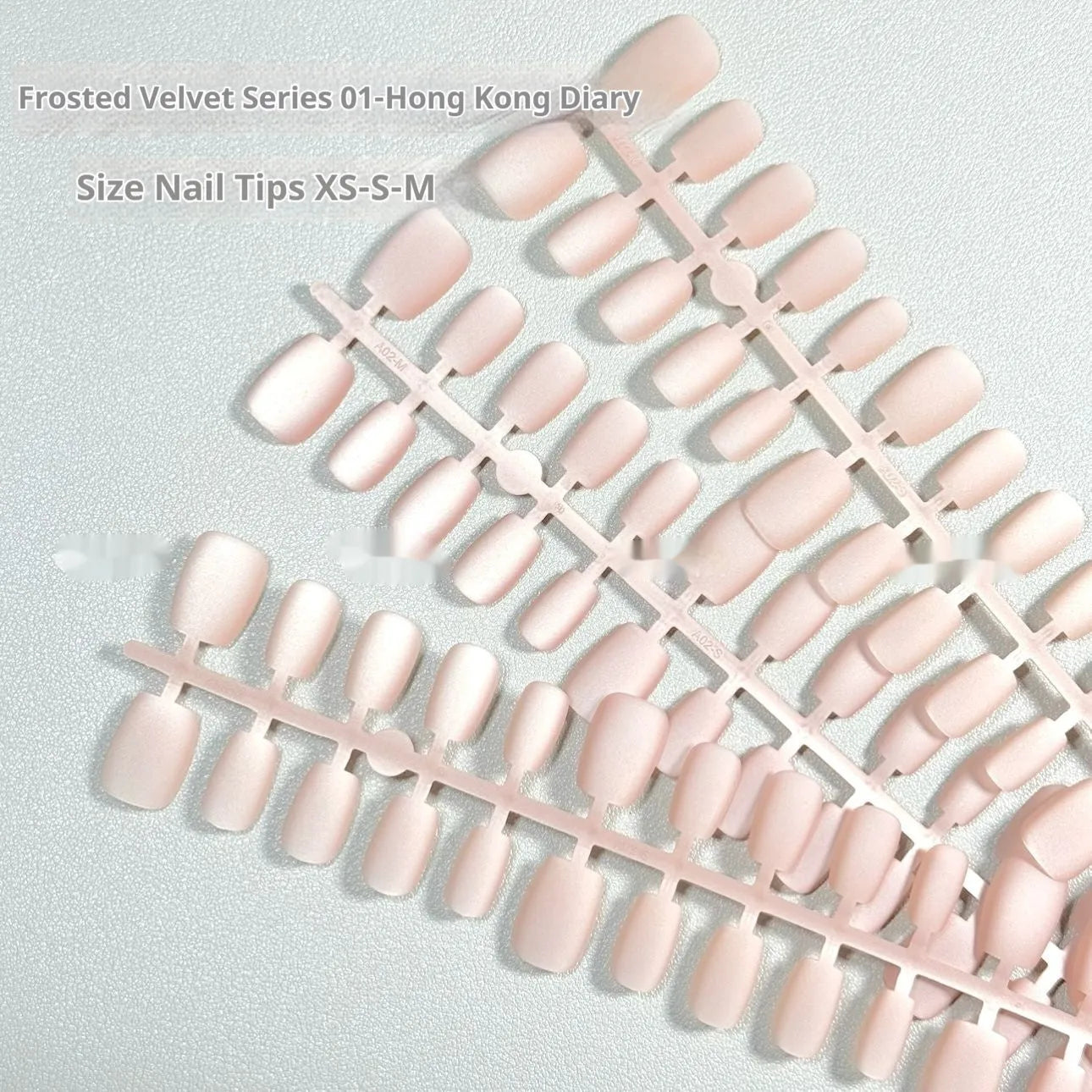 Set of Frosted Velvet and Cat's Eye effect false nails in short ladder sizes on a clear background.