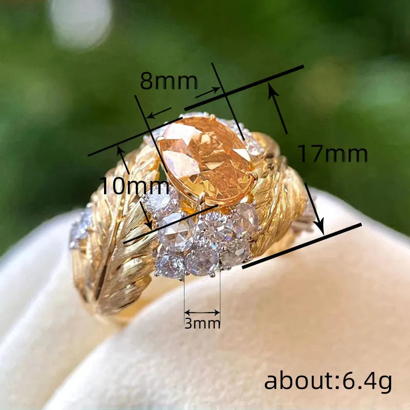 Gold coloured women's ring with embossed feather design and yellow zircon stones.