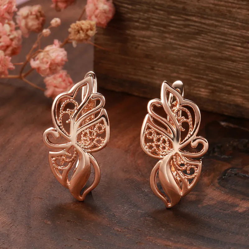 Pair of rose gold hollow carved geometric earrings with rhinestone accents on copper base