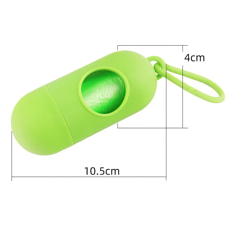 Compact black dog poop bag holder with a metal hook and Velcro strap, showing scale.