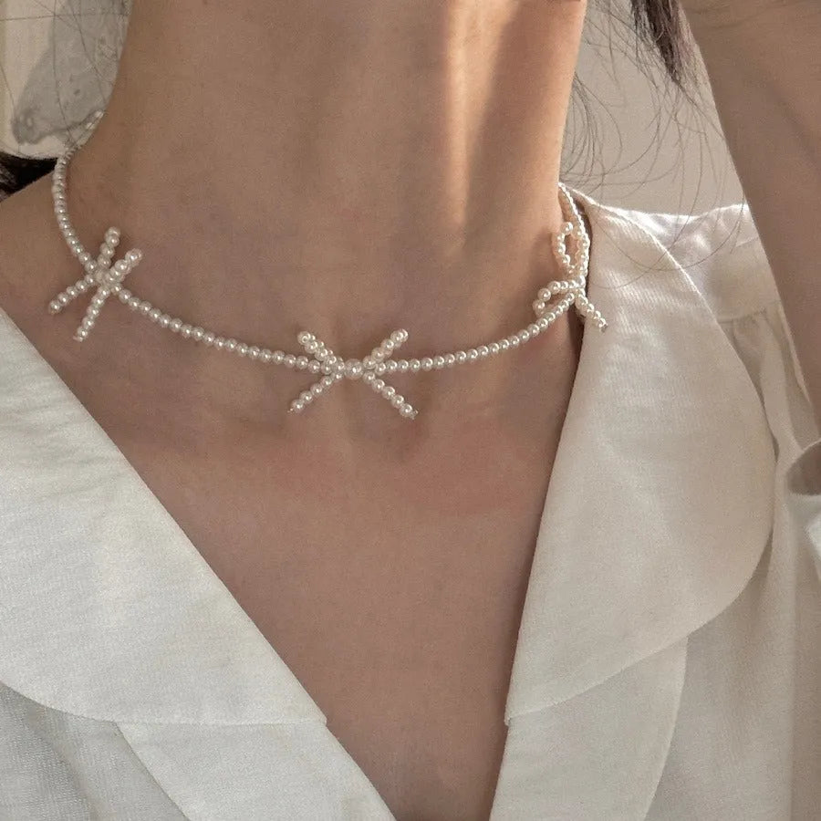 White adjustable pearl necklace with bow detail measuring 31-40cm