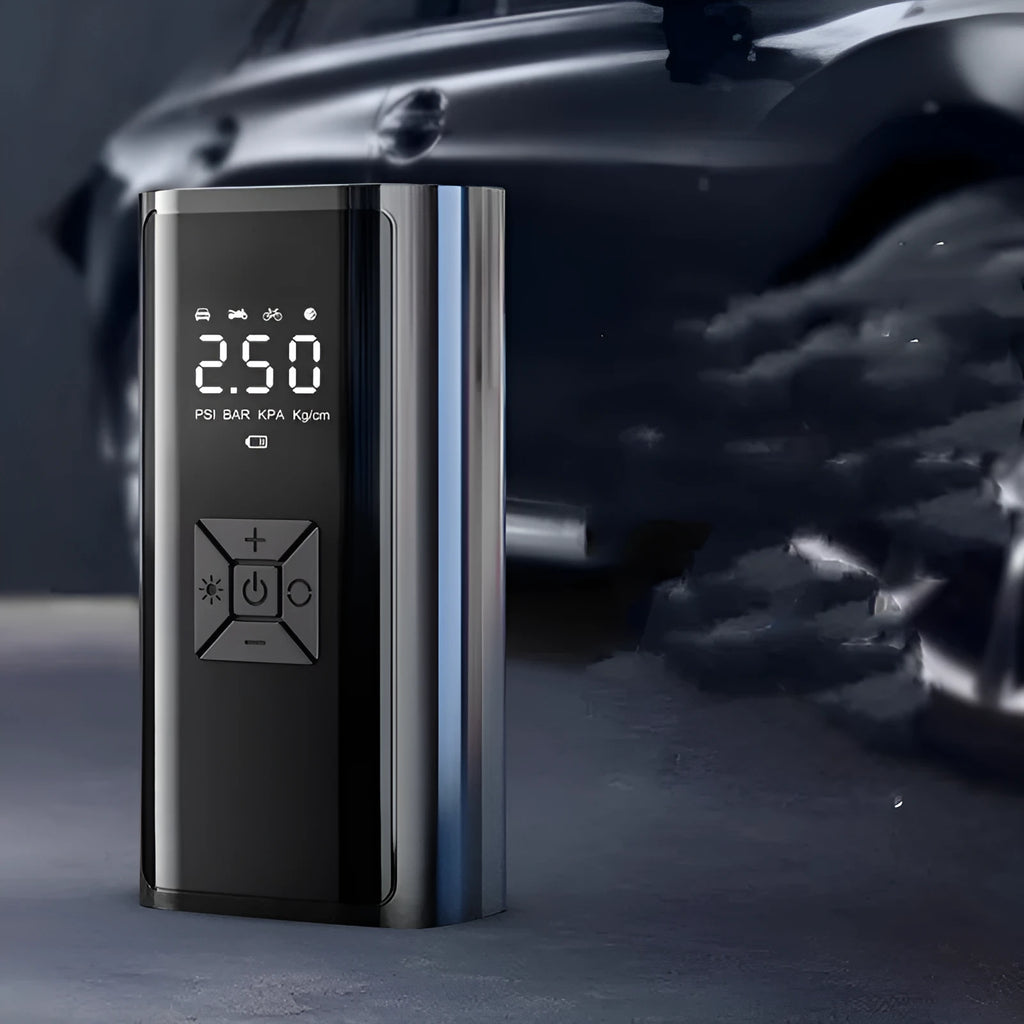 Portable wireless digital car tyre pump with display, hose, and cables on a grey background.