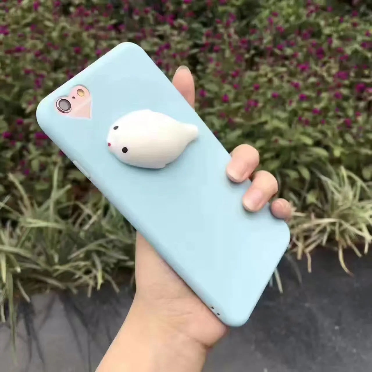 Soft pink silicone iPhone case with a raised 3D cartoon cat design on the back.