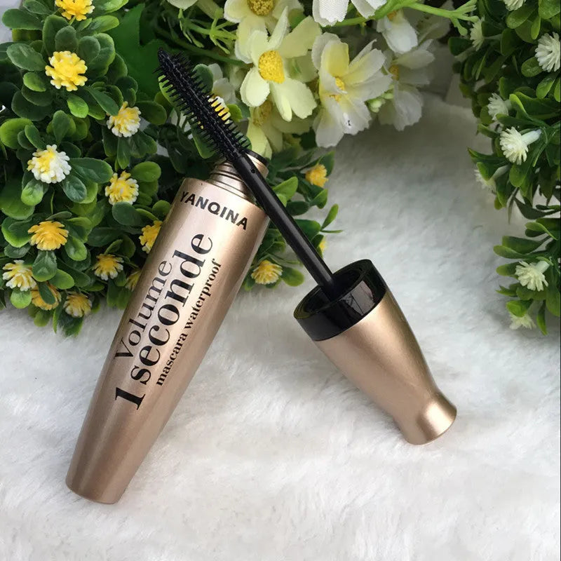 Gold tube black mascara in a vertical orientation against a light background