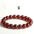 Natural orange red garnet ball bracelet with a silver Ruyi charm on a crystal beaded strand.