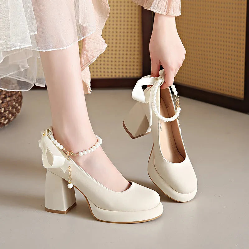 Women's beige Mary Jane shoes with chunky heel and ankle-strap buckle on a neutral background