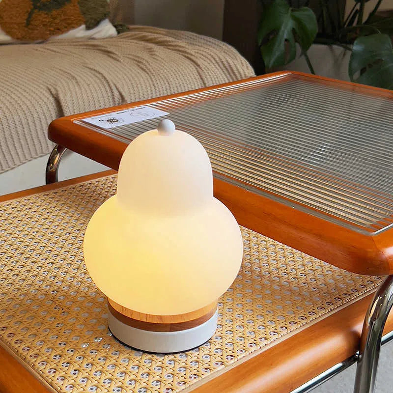 White pear rechargeable LED touch table lamp with PE shade on a bedside table