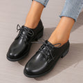 Black women's low-top work shoes with a chunky mid heel and soft rubber sole.