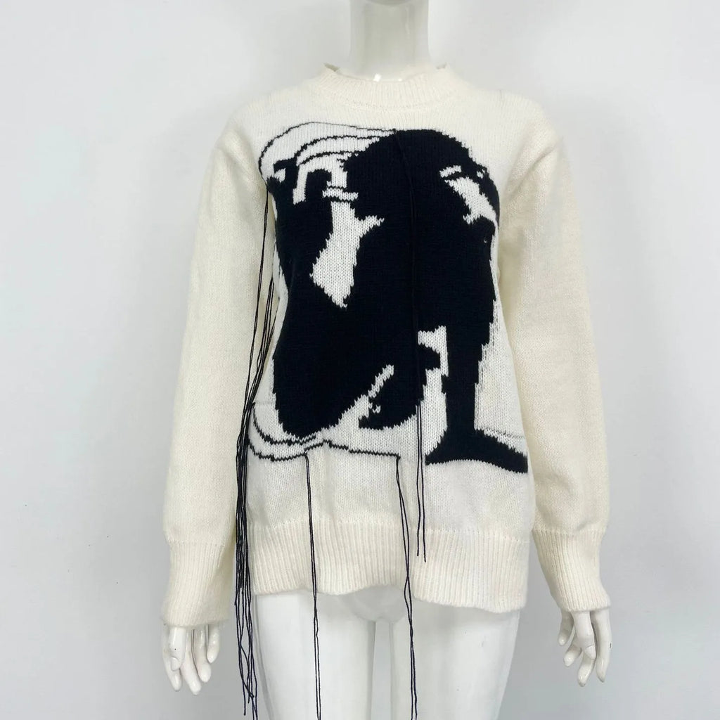 Grey women's loose alpaca wool sweater with abstract pattern and tassel design details on sleeve.