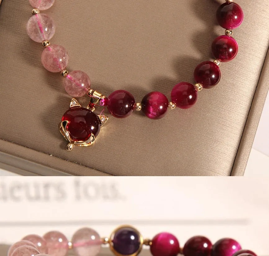 Simple women's bracelet with a strawberry crystal on a black elastic rope.