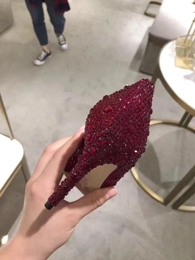 Gold women's pointed toe high heels with rhinestone decoration and a stiletto heel.