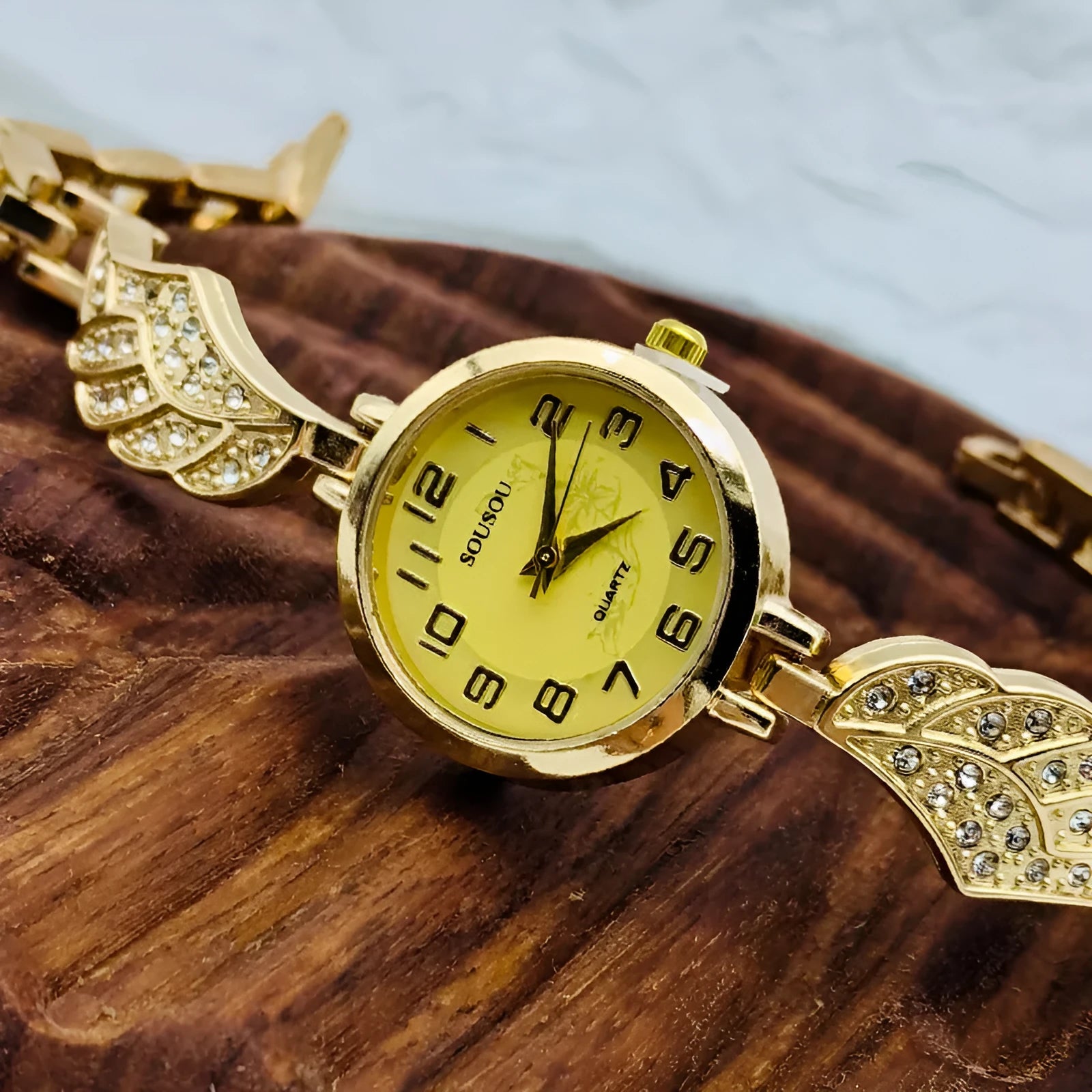 Women's stainless steel watch with round dial showing gold face colour option on wrist.
