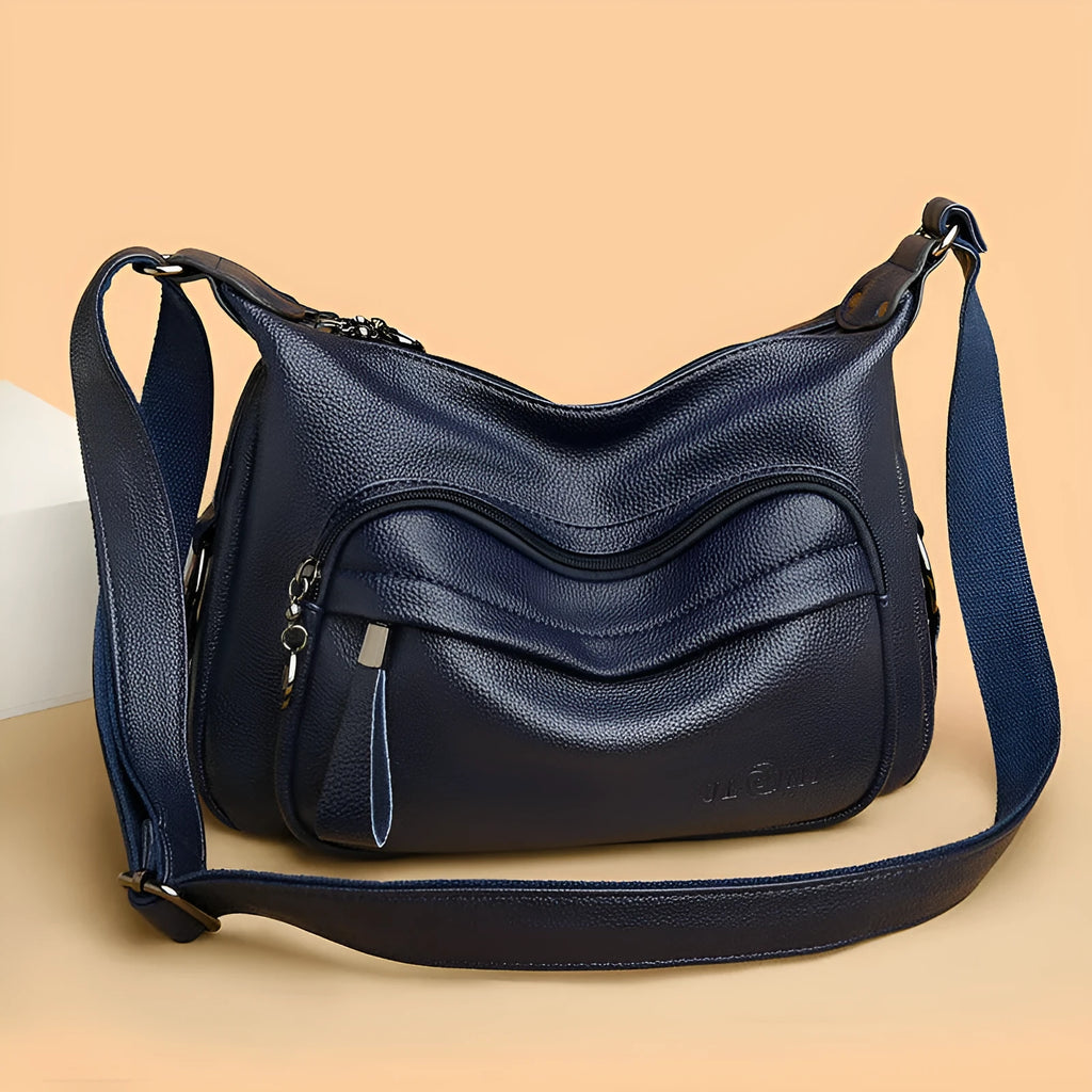 Large blue PU leather crossbody bag for women showing horizontal square shape and internal organiser pockets.