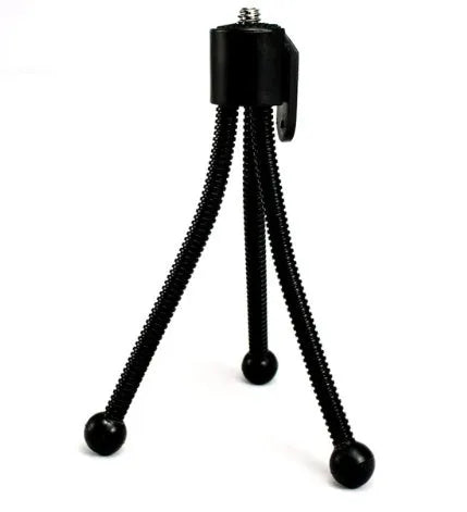 Small aluminium folding tripod with ball head mounted with smartphone on desktop