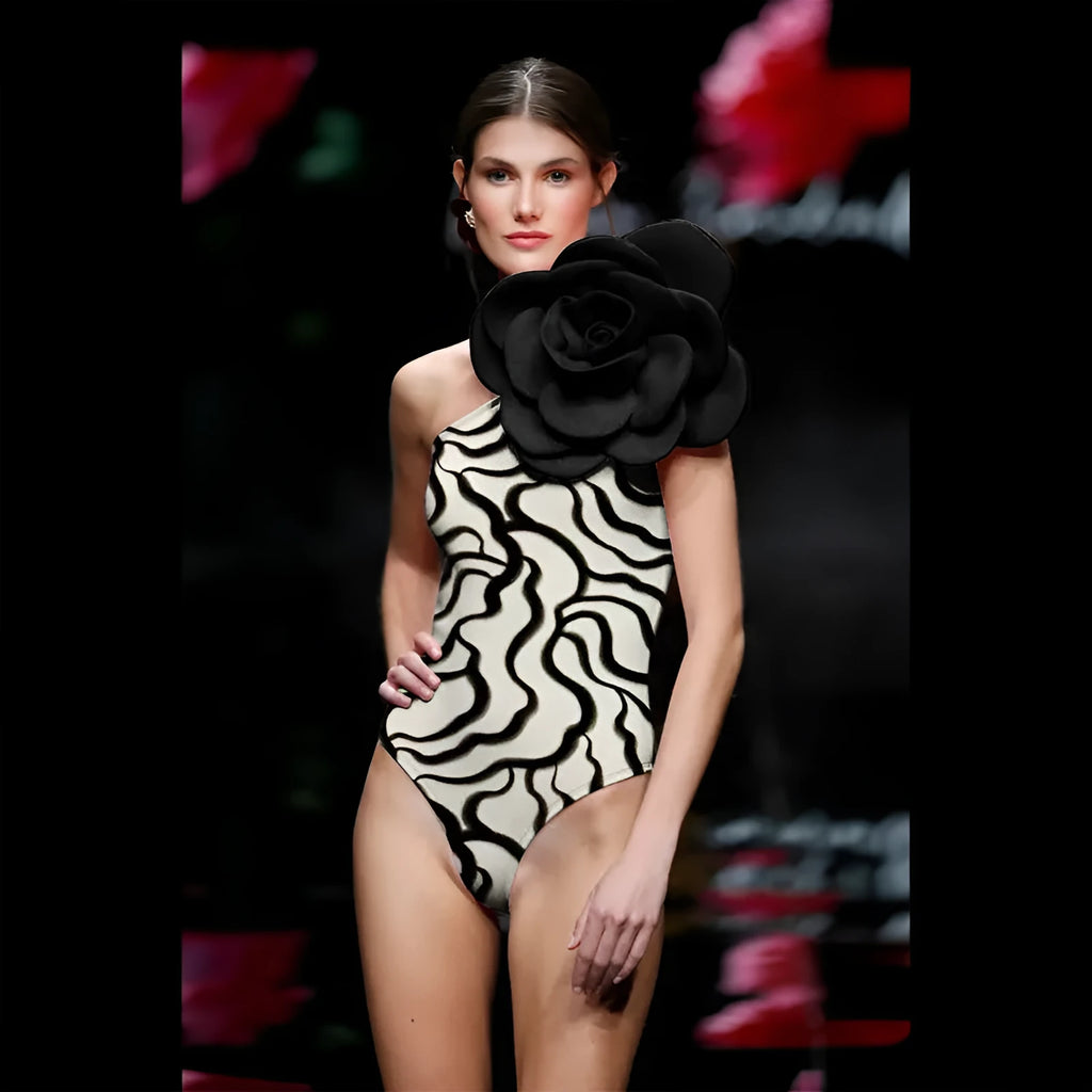 Black one-piece swimsuit with white three-dimensional flower design, form-fitting European American style.