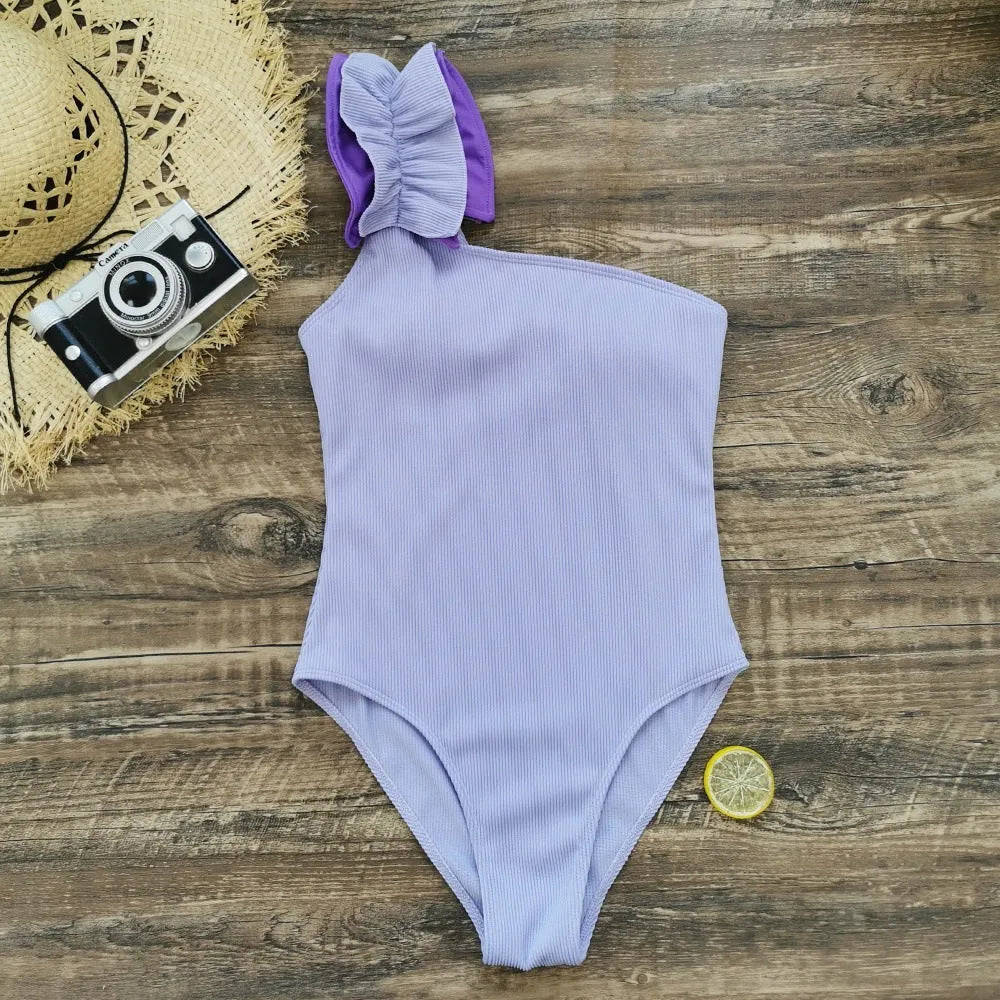 Women's single-shoulder suspender one-piece swimsuit in solid colour with high-waist design.