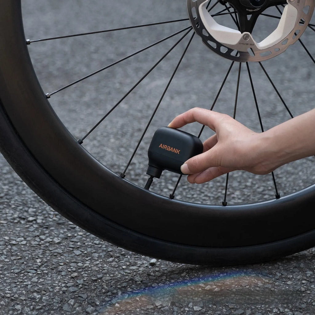 Black mini electric bicycle pump with USB charging cable and waterproof storage bag