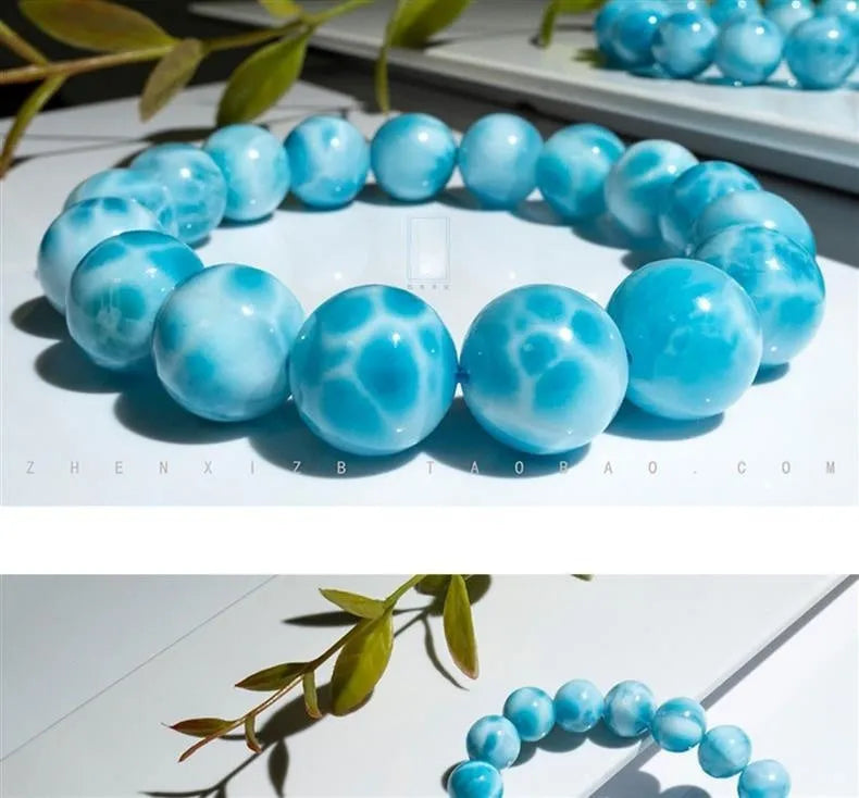 Blue handmade bodhi bracelet with natural crystal sea-pattern beads and pearl accents on a white background.