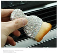 White PVC car interior cleaning brush on a car dashboard, showing its compact size and soft bristles.