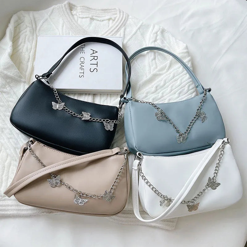 Black butterfly chain underarm bag with crossbody strap showing internal mobile phone and document compartments