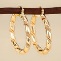 Women's geometric copper earrings with ring and line design elements in golden colours