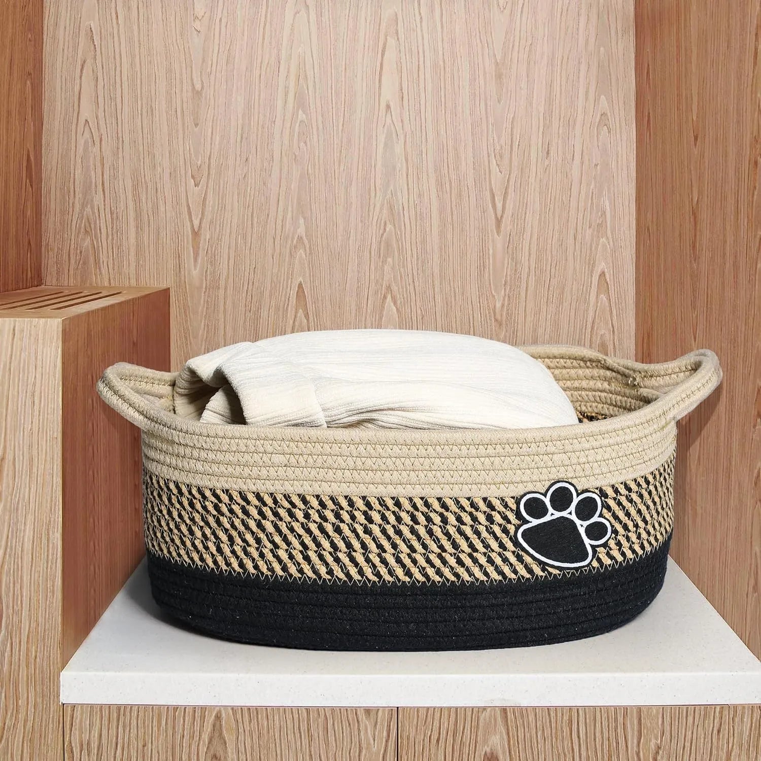 Hand-woven light beige cotton rope storage basket with wooden handle for home organisation