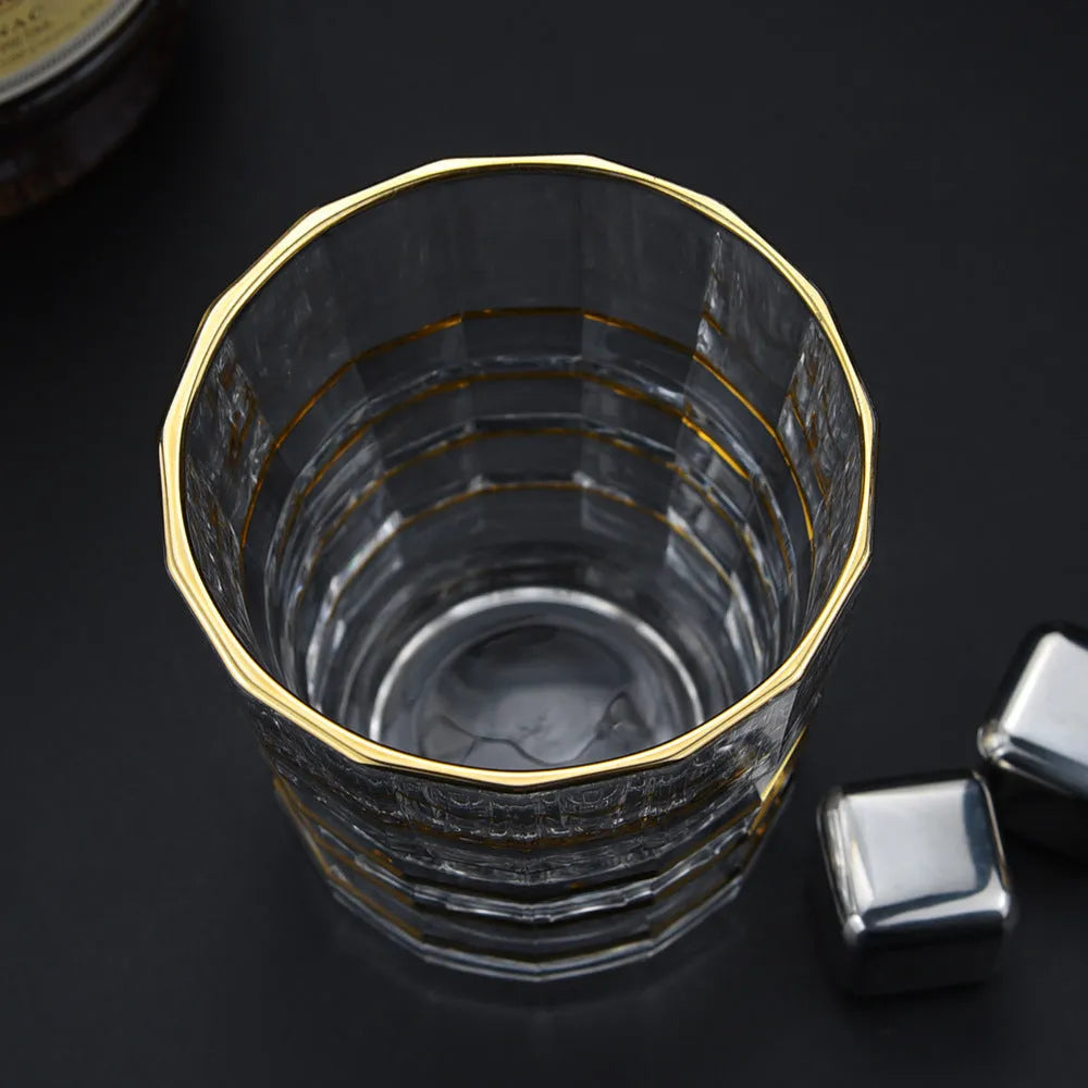 Crystal glass whiskey shot glass with solid gold finish on a bar counter