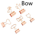 Gold metal decorative clip showing bow, cactus, cat, flamingo, and love shape designs.