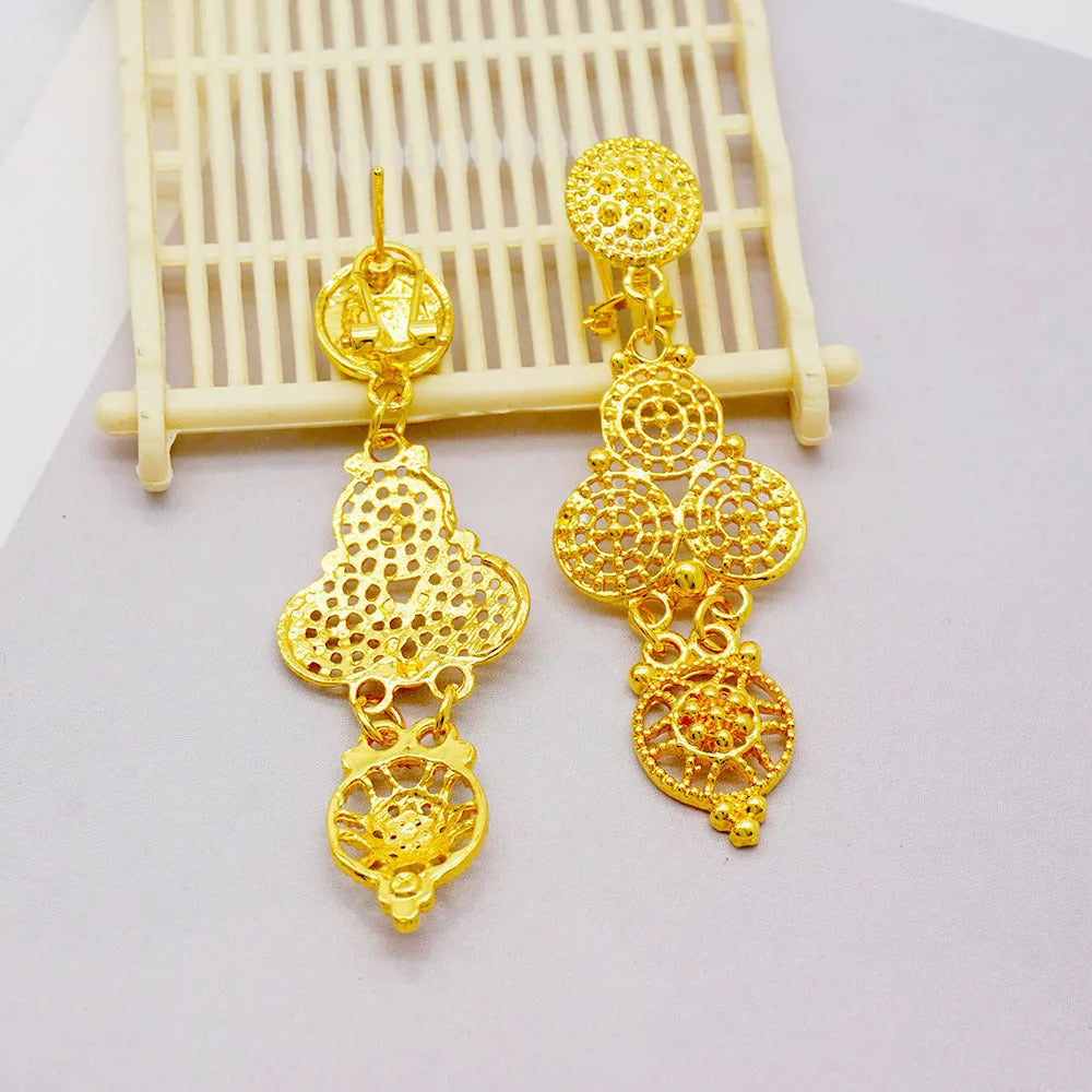 Gold women's jewellery set with tassel necklace, water wave chain, earrings, bracelet, and ring on display