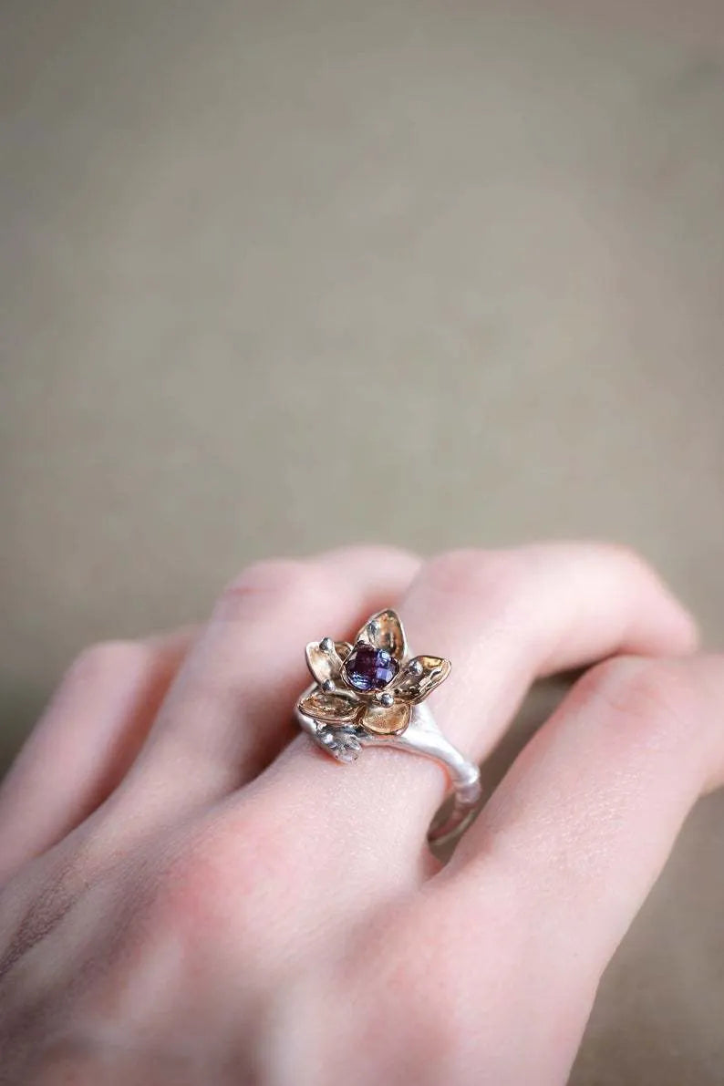 Silver two-tone floral geometric alloy ring for women on a grey background, showing detail.