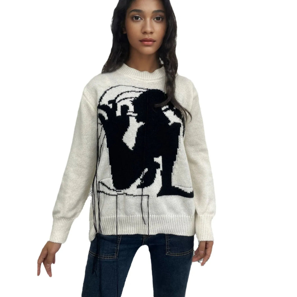 Grey women's loose alpaca wool sweater with abstract pattern and tassel design details on sleeve.