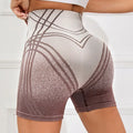 Women's high waisted gradient fitness shorts in black, shown for yoga or running.
