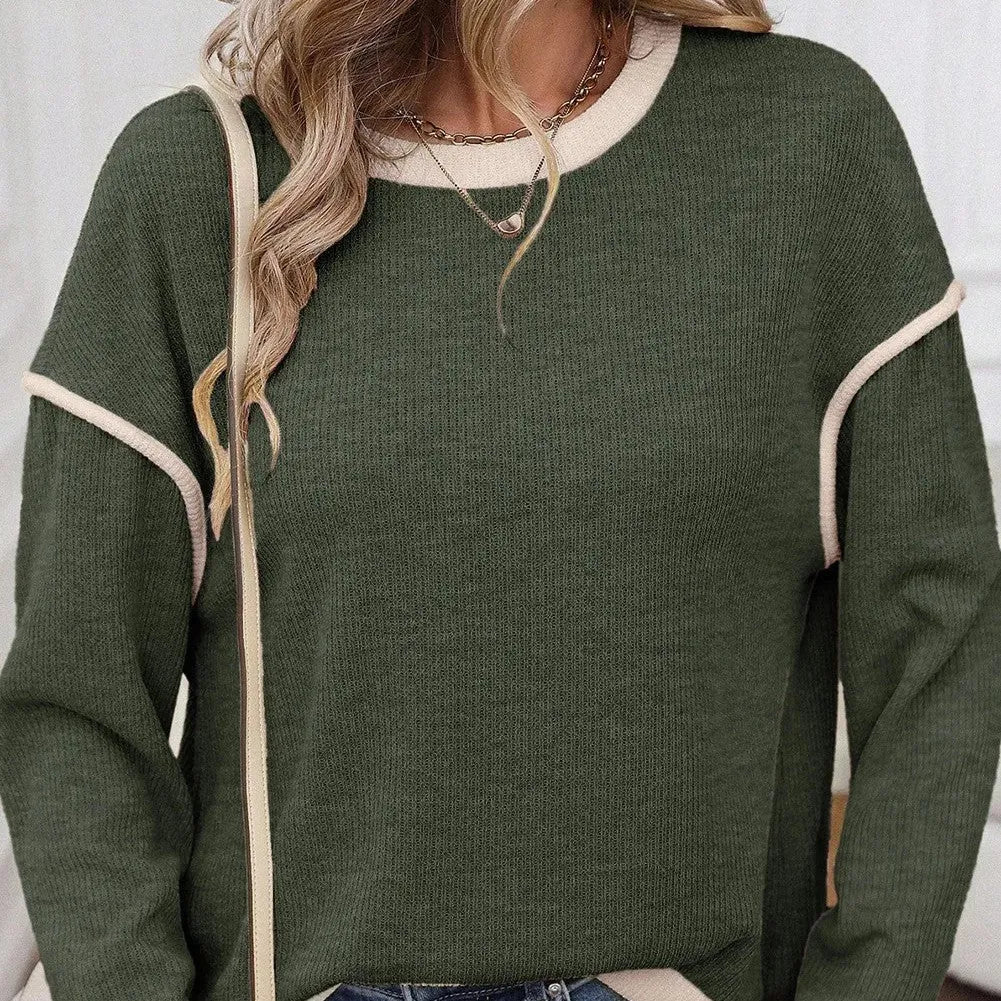 Women's loose grey knit top with green four leaf clover pattern trim on the sleeves and hem.