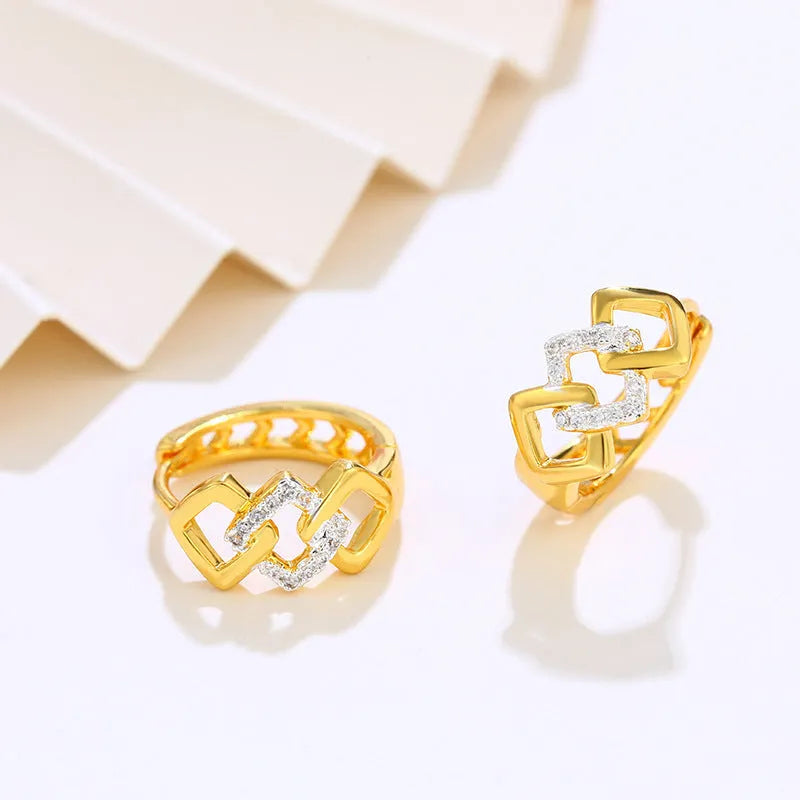 Gold electroplated geometric hollow-out earrings with ear clip fastening on white background