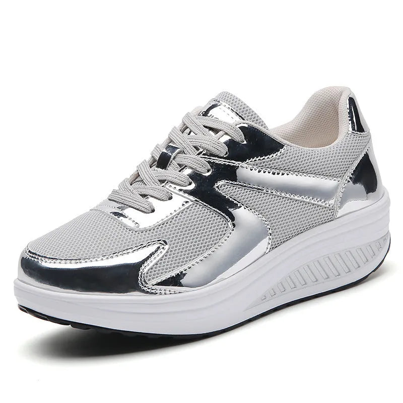 Women's gold platform trainers with mesh upper and cross-strap design showing 3-5cm heel elevation