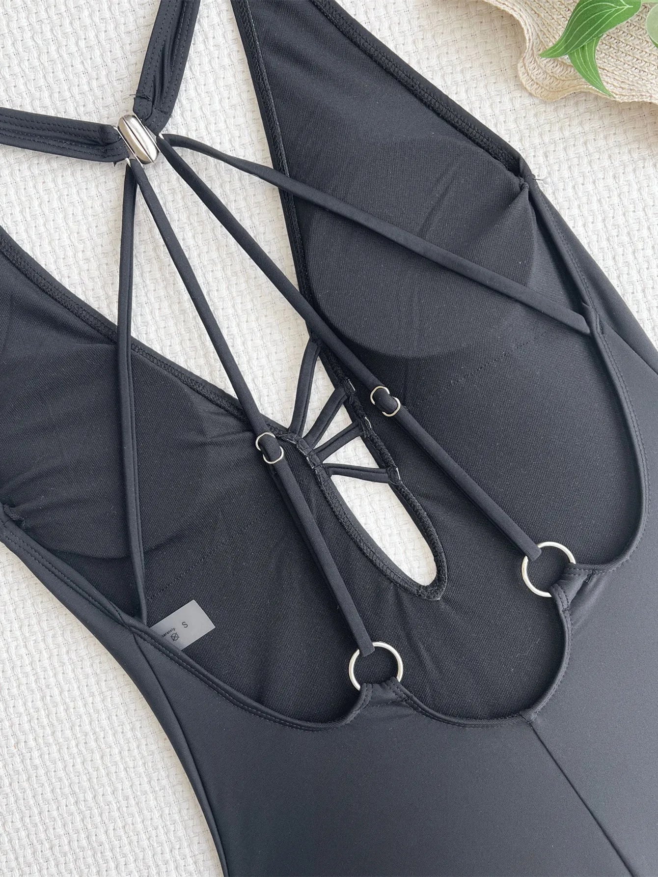 Black solid colour one-piece nylon swimsuit for ladies on a mannequin, showing front design.