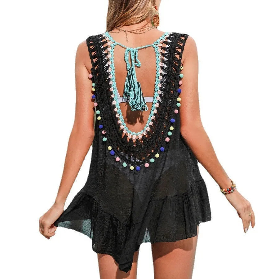 Black hand-crocheted acrylic beach cover-up vest with ruffled cut-out design on a hanger