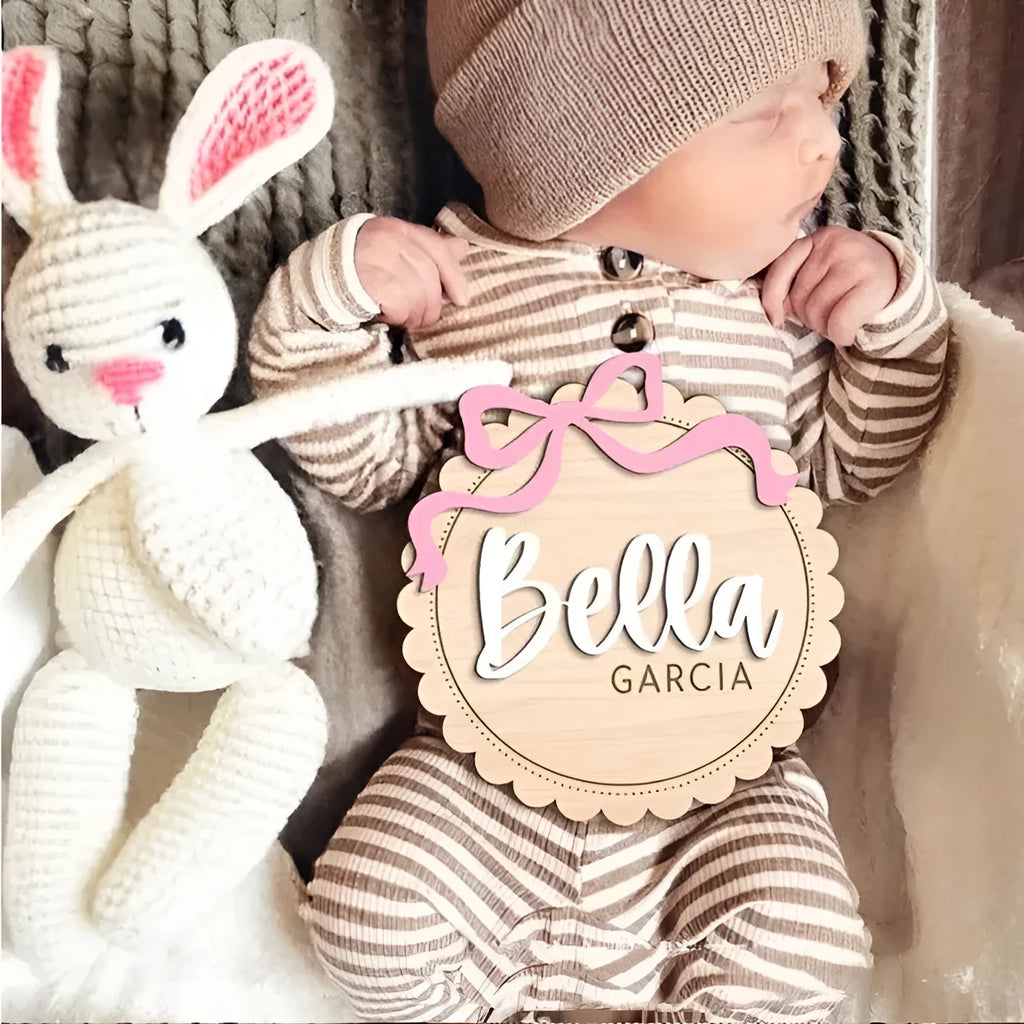 Square wooden baby room ornament with space for a customised name, shown in two size options.