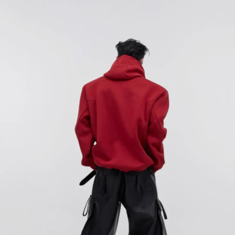 Men's red hooded sweater with heavy shoulder pads and raised silver metal 3D printing on the front.