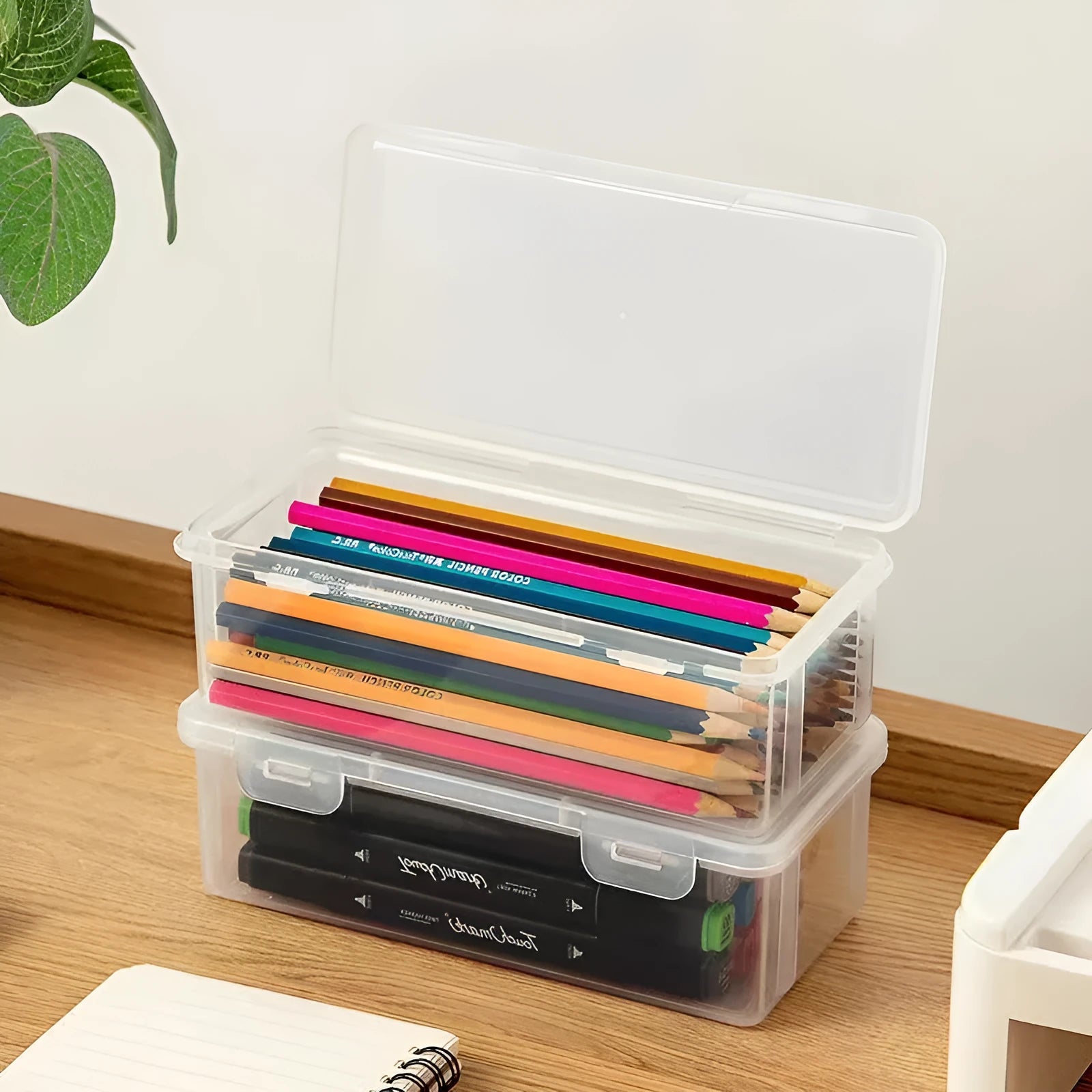 Clear plastic pencil storage box with large capacity for organising stationery and children's art supplies.