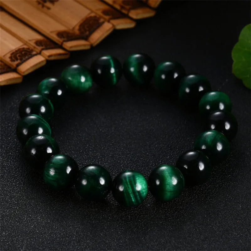 Green tiger eye stone bracelet with polished geometric beads on a wrist.