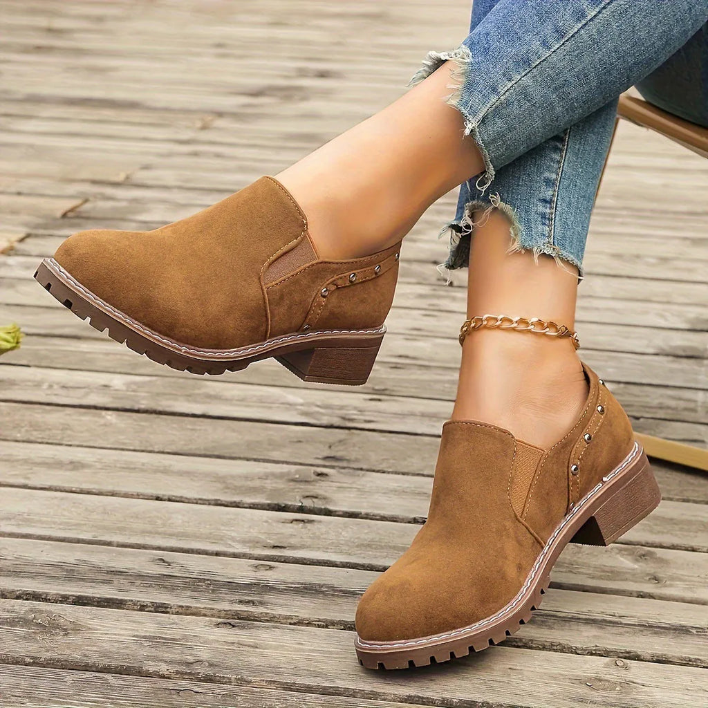 Women's light brown suede ankle boots with a low thick heel and elastic band fastening.