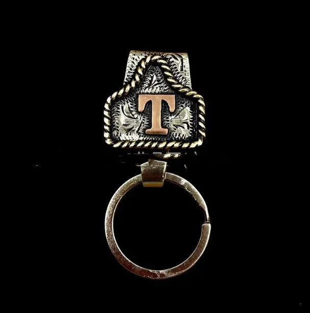 Handmade metal cow tag belt key holder keychain with a lettered tag and clip.