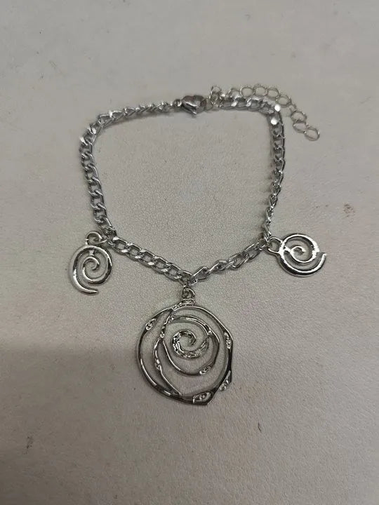 Women's spiral donut charm jewellery set with gold necklace, bracelet and earrings on white background