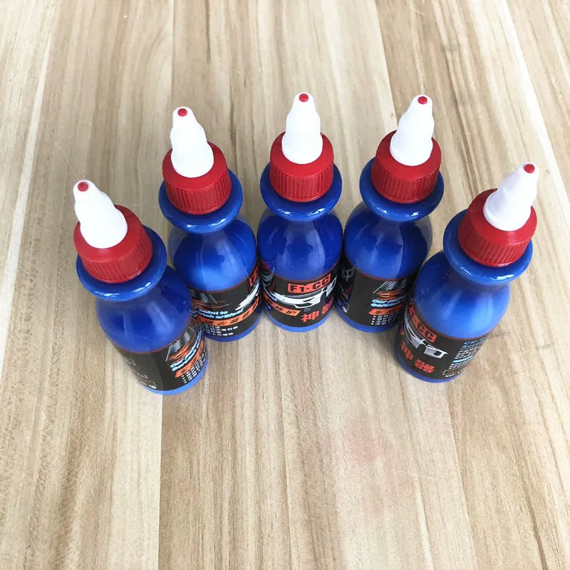 Small blue wiping tool and bottle of automotive scratch repair agent kit for car paint