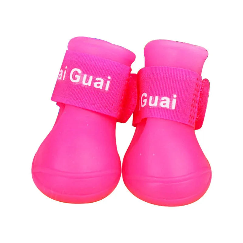 Soft silicone pet rain boots in royal blue on a wet pavement, non-slip sole visible